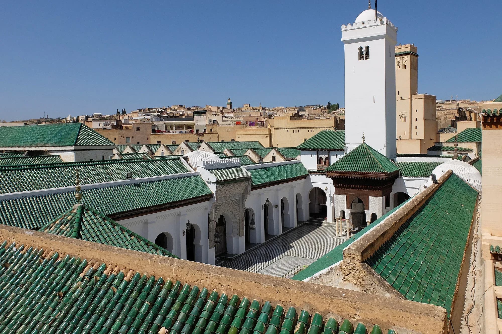 Tejados de tejas verdes y minarete de la mezquita Al Quaraouiyine de Fez vistos desde una azotea
