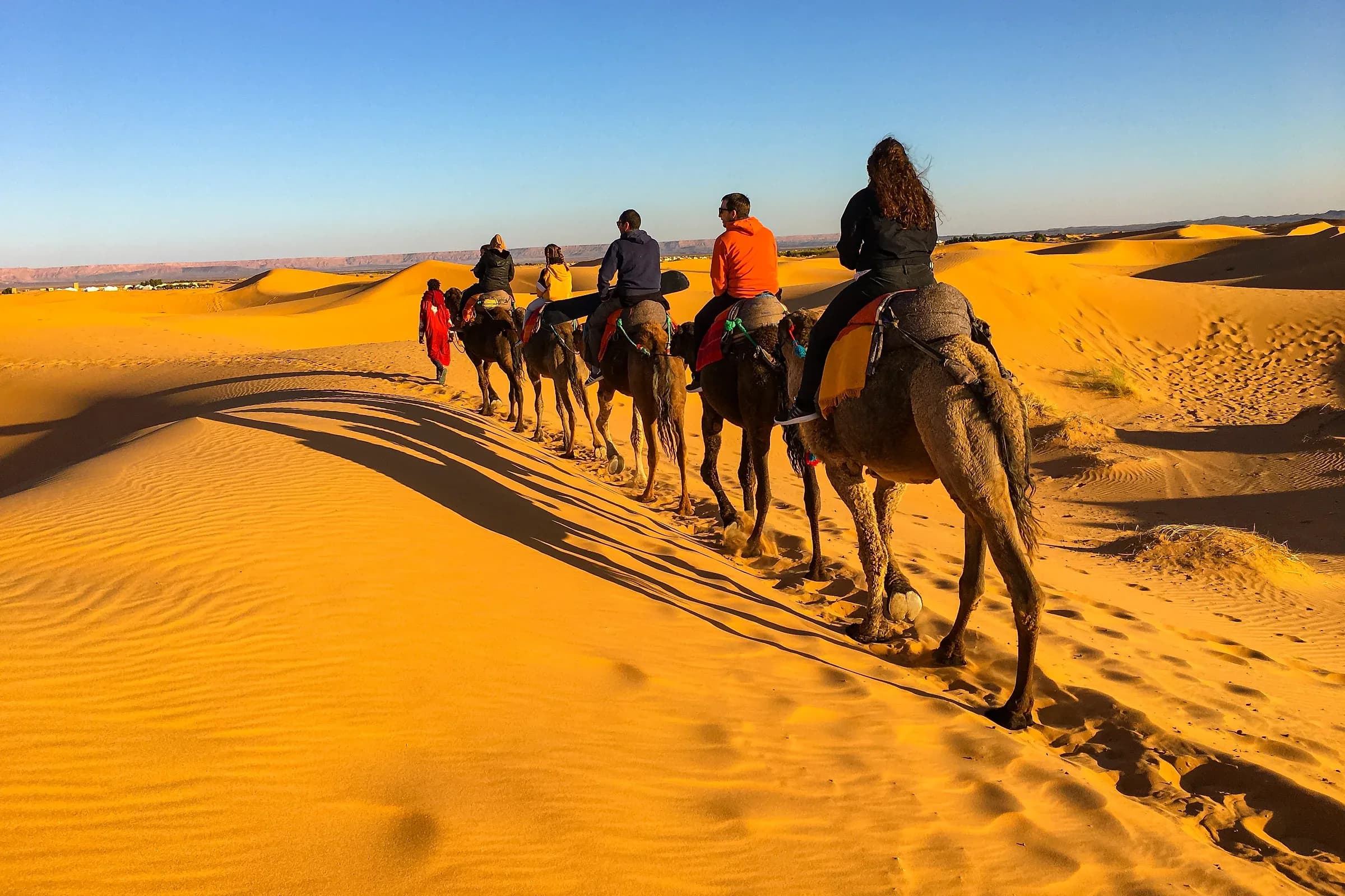 Caravana de dromedarios cruzando las dunas de Merzouga en Erg Chebbi