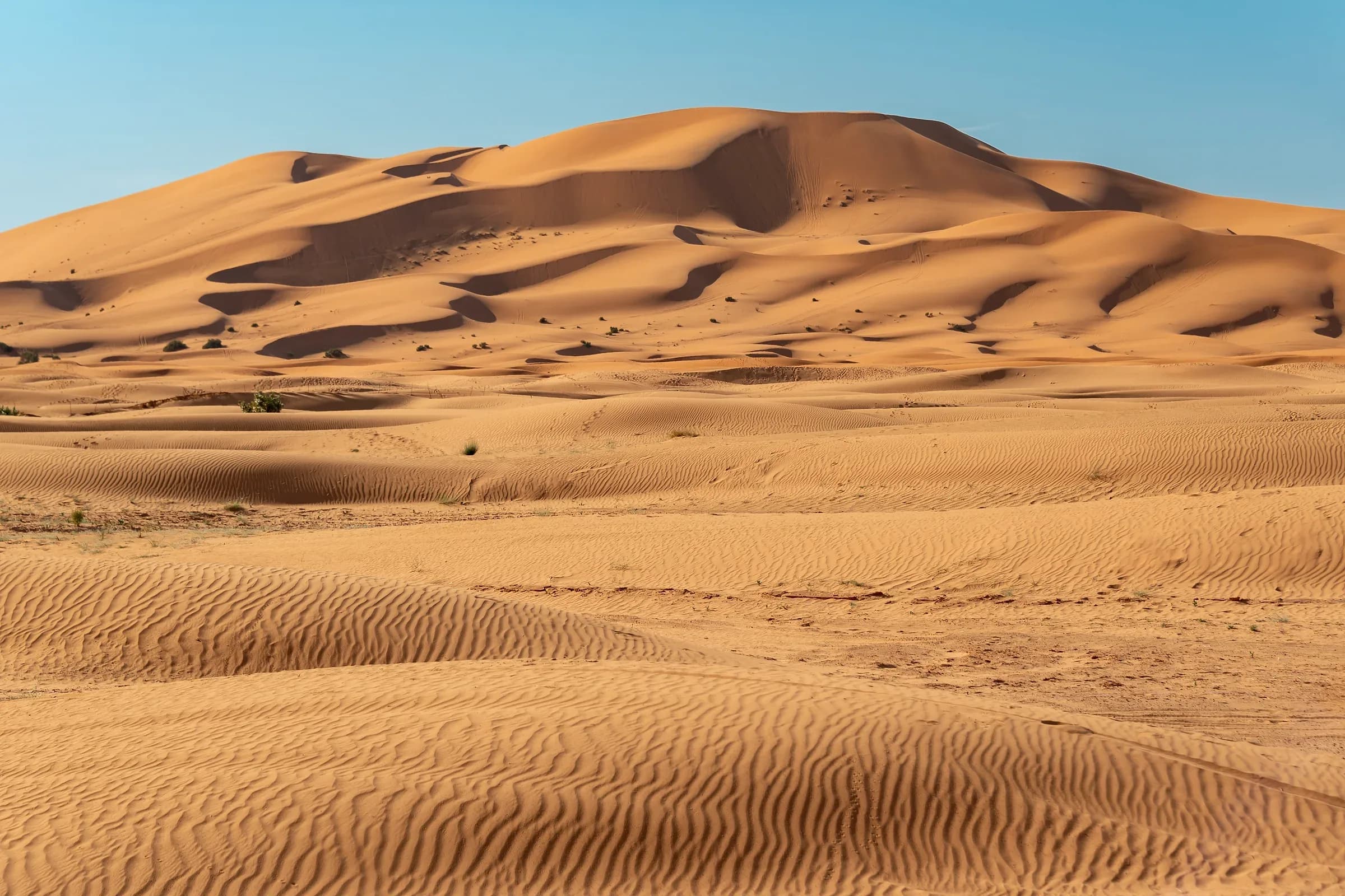 Dunas altas de Erg Chebbi con ondulaciones de arena bajo el cielo azul, Merzouga