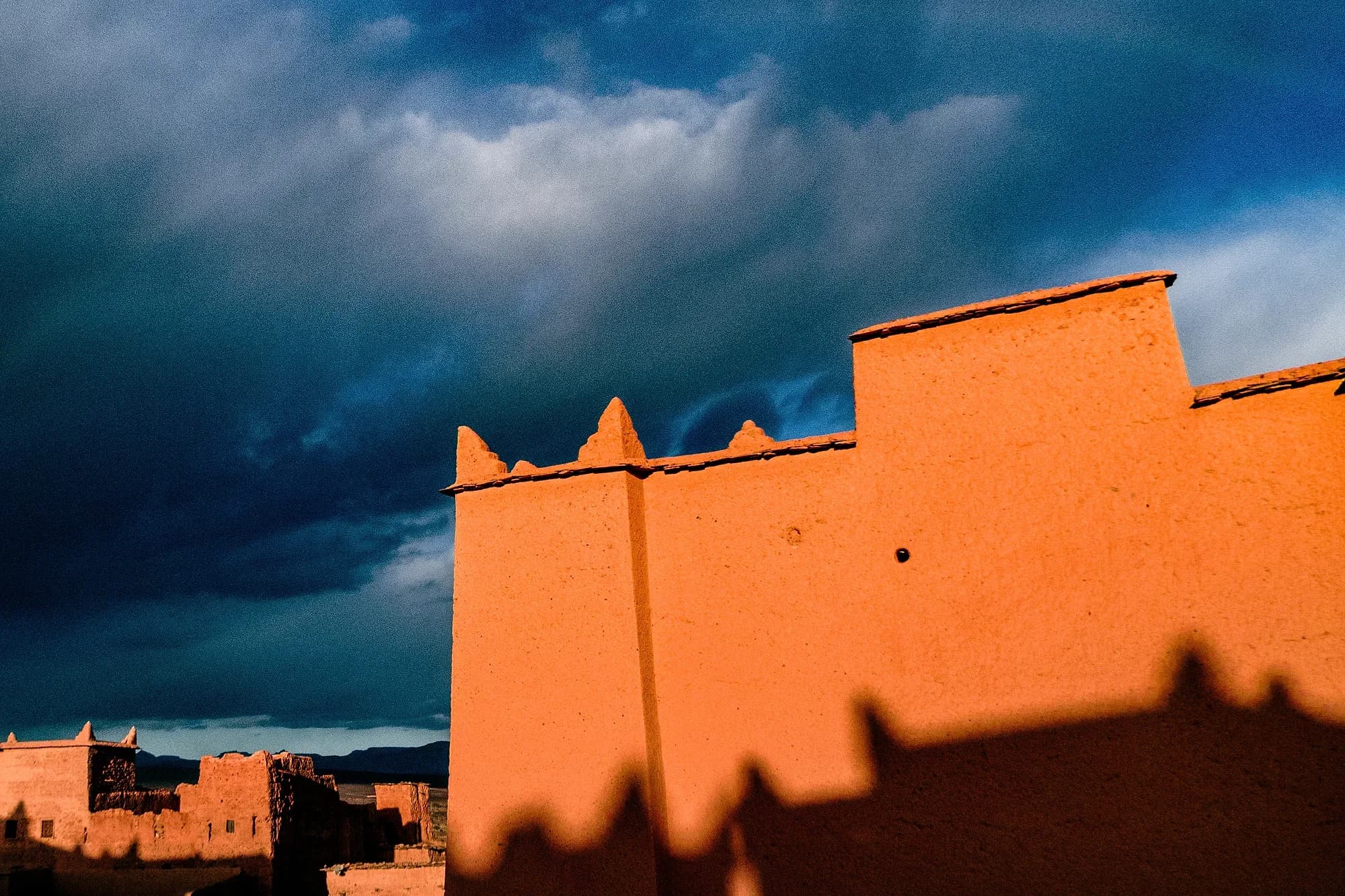 Muros de una kasbah de adobe en N'Kob bajo un cielo de tormenta