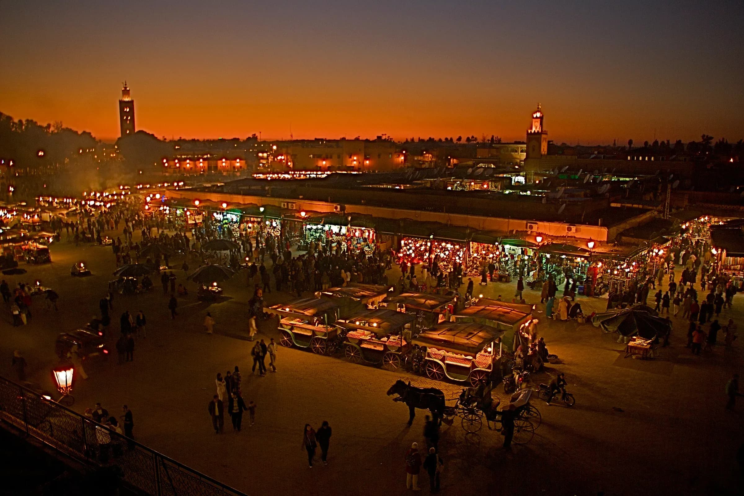 Plaza Jemaa el-Fna al anochecer con los puestos de comida y el minarete de la Koutoubia, Marrakech