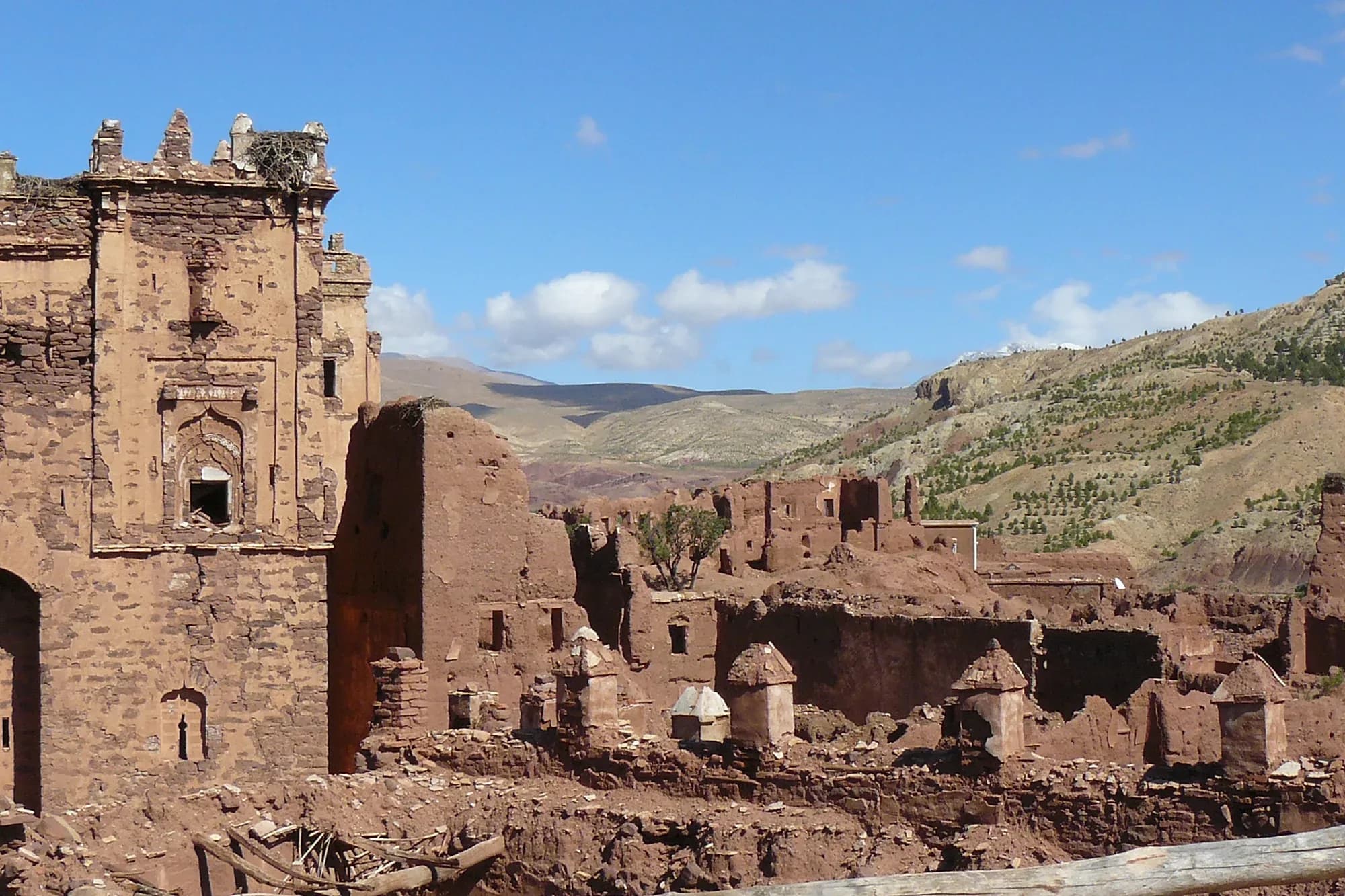 Torre y muros en ruinas de la kasbah de Telouet con las colinas del Alto Atlas al fondo
