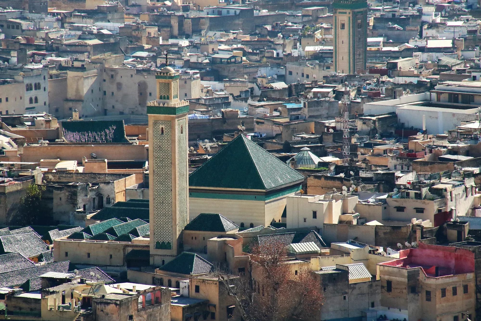 Minarete y tejado de tejas verdes entre las azoteas de la medina de Fez el Bali