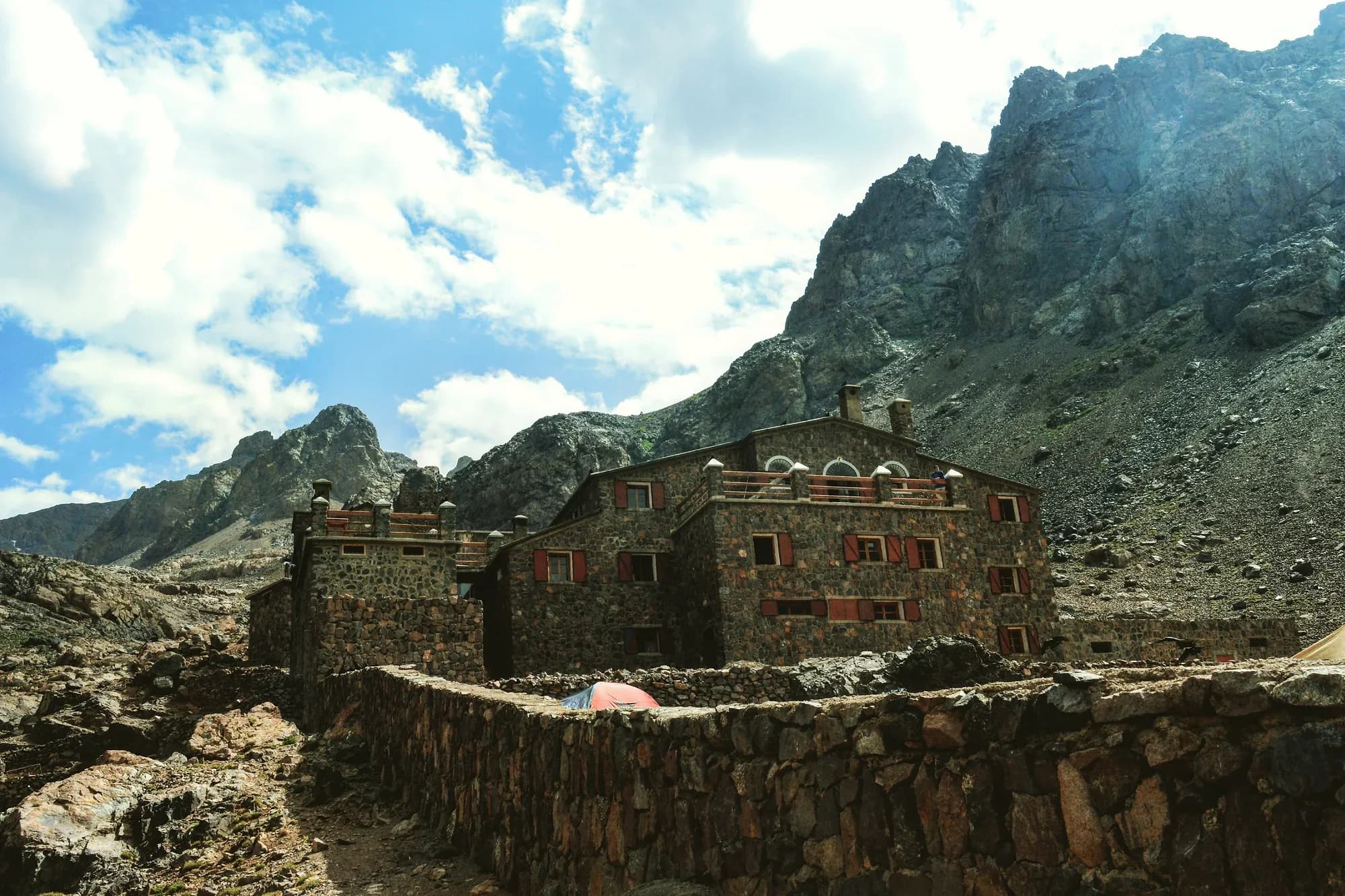 Edificio de piedra del refugio del Toubkal entre picos rocosos del Alto Atlas