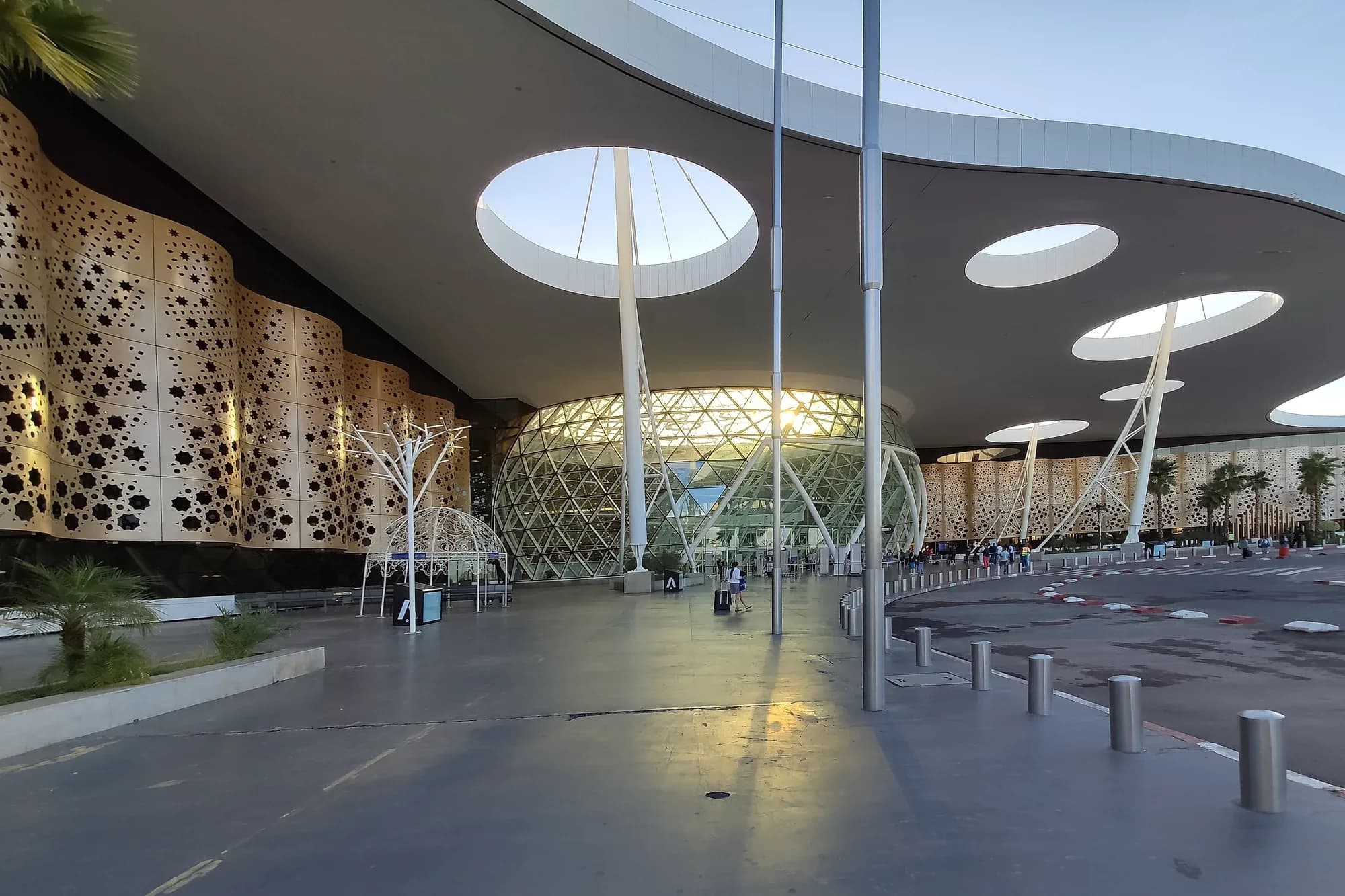 Entrada de la terminal del aeropuerto Marrakech-Menara con su fachada calada y cubierta blanca