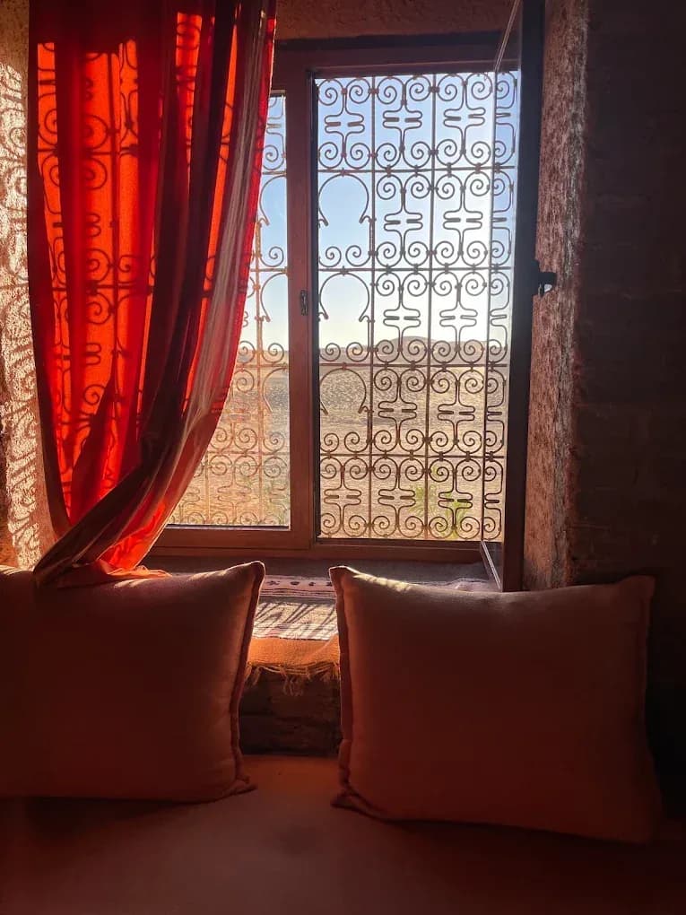 Ventana de una kasbah con cortinas rojas